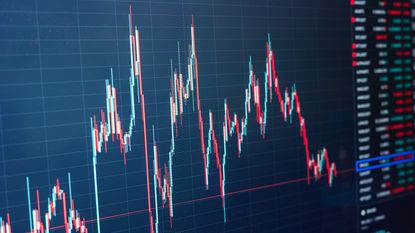 businessman using a laptop to check candlestick chart stock market data